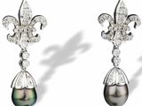 une paire de boucles d'oreilles en perles noires et diamants sur fond blanc