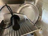 a metal cutting machine that is sitting in a kitchen