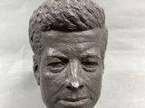 statue of a man ' s face on a wooden base