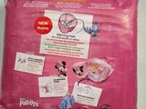 pink bag of baby diapers sitting on a table with stickers on it