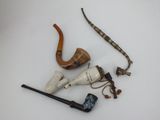a lot of different types of smoking pipes on the table