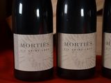 three bottles of red wine sitting on a table