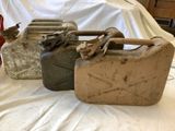 three old canisters sitting on a bed next to a can of soda