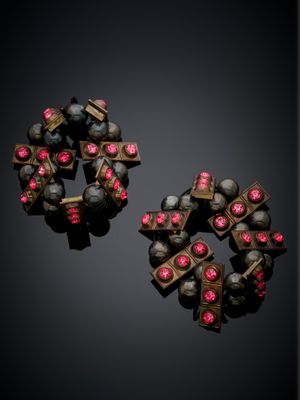 deux paires de boucles d'oreilles ornées de pierres roses sur un fond noir