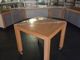 a wooden table with a glass top in the middle of a room