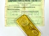 un lingot d'or posé à côté d'un ticket de caisse sur une table