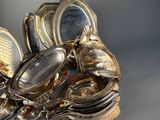 a lot of silver dishes and spoons sitting on a table