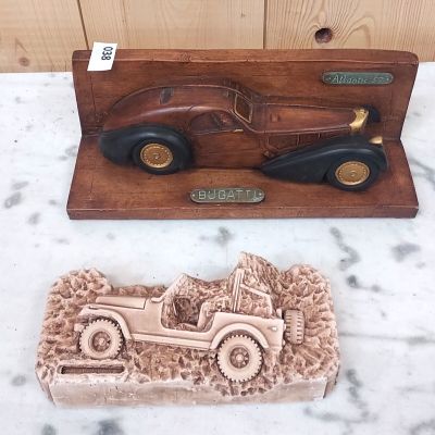 Des sculptures représentant des voitures anciennes sont exposées sur un socle en marbre