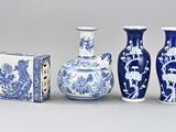 three blue and white vases and a box on a gray surface
