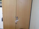 une petite table avec un tabouret devant une armoire