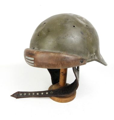 casque posé sur un socle en bois, muni d'une lanière en cuir autour du cou