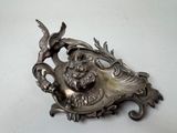 a silver plate with a bird on it on a table
