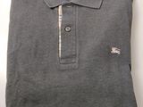 a grey polo shirt with a white stripe on the collar