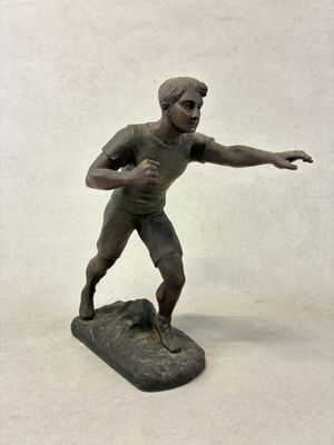 une figurine en bronze représentant un homme sur une planche de surf