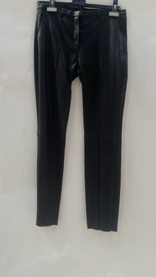 a pair of black leather pants hanging on a hanger