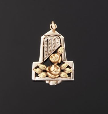 a gold and silver bell with a rose on it