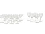 Plusieurs verres à vin transparents sont alignés sur une surface blanche