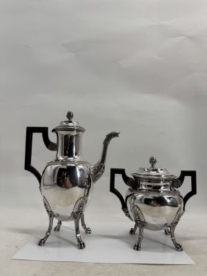 two silver teapots and a silver teapot on a white surface