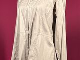 beige leather jacket on a mannequin stand against a red background