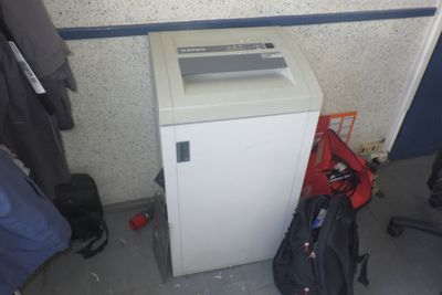 une image représentant une petite déchiqueteuse à papier blanche à côté d'un sac à dos
