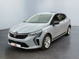 une voiture argentée garée dans une pièce blanche au sol noir