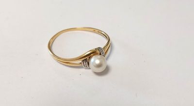 a close up of a gold ring with a pearl and diamonds