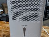 a white air purifier sitting on a wooden table