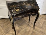 bureau peint en noir et or, avec des tiroirs et des tiroirs sur le dessus