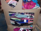 un chariot en carton sur lequel sont disposés de nombreux types de vêtements différents