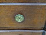 a wooden dresser with three drawers on top of it