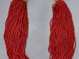 un gros plan d'un collier rouge posé sur une surface blanche