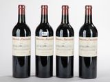 trois bouteilles de vin rouge sont alignées sur une surface blanche