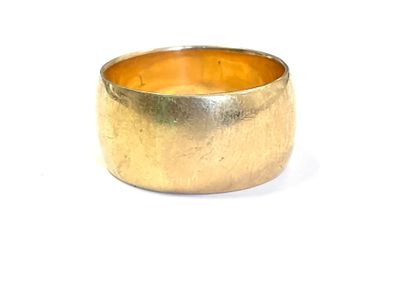 gros plan d'une bague en or sur une surface blanche