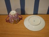 a white plate and a pink and white cup on a wooden table