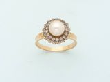 two gold rings with pearls and diamonds on a white surface