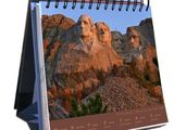 a close up of a desk calendar with a picture of mount rush