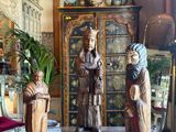 three figurines sitting on top of a table in a room