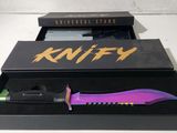 a knife in a black box with a purple handle