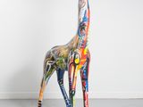 a giraffe that is standing in a room with a white wall