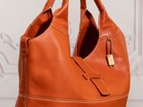 a brown leather handbag sitting on top of a wooden table