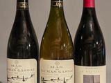trois bouteilles de vin sont alignées sur une table