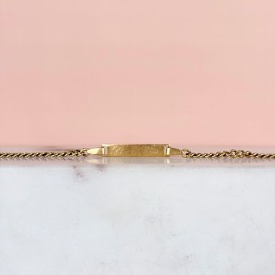 une boîte en marbre blanc avec une chaîne en or sur fond rose
