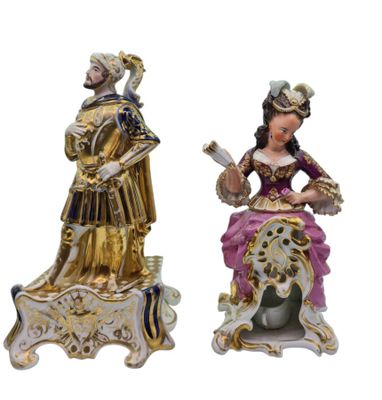 two figurines of a woman and a man sitting on a bench