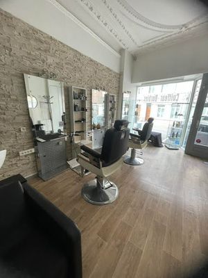 a picture of a hair salon with chairs and a mirror