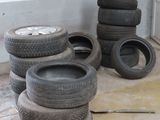 a pile of tires sitting on the floor next to a pile of other tires