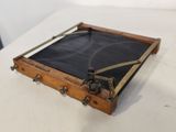une petite boîte en bois dont l'intérieur est recouvert d'un tissu noir