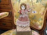 a doll that is sitting on a chair in a room