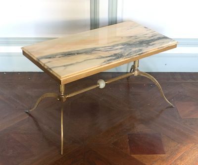 une photo d'une table basse au plateau en marbre posée sur un parquet