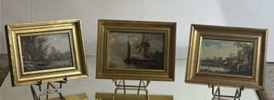 three paintings on display on a glass table