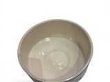 a white bowl with a black rim on a white surface